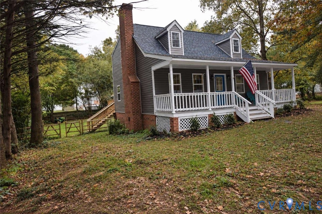 7300 Key Deer Court, Deer Run, Midlothian, VA 23112 Cape Cod exterior featuring horizontal siding, a full-length covered front porch with white railing, a prominent exterior brick chimney, and dual dormer windows