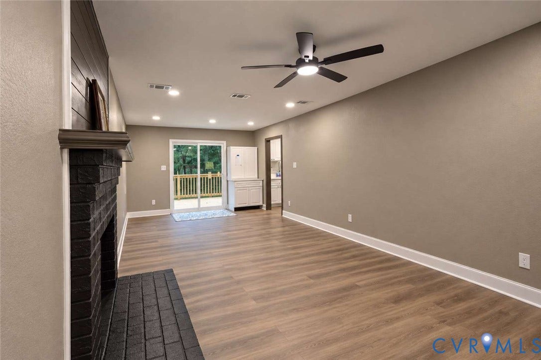 7300 Key Deer Court, Deer Run, Midlothian, VA 23112 Painted brick fireplace with a wood mantle, wood-finish flooring, recessed lighting, ceiling fan with integrated light fixture, and glass sliding doors