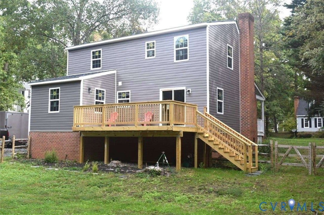 7300 Key Deer Court, Deer Run, Midlothian, VA 23112 Two-story residence featuring gray horizontal siding, an exterior red brick chimney, a wood deck with staircase, and a brick foundation