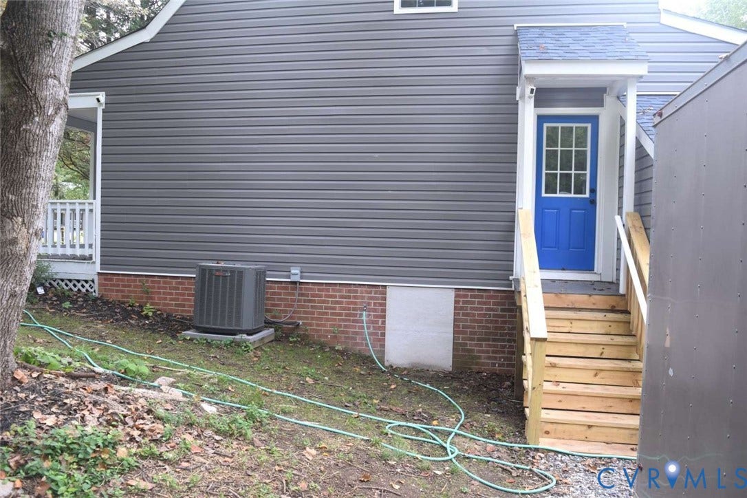 7300 Key Deer Court, Deer Run, Midlothian, VA 23112 Exterior featuring dark horizontal siding, a red brick foundation, an elevated wood staircase with handrails, and a multi-pane glass entry door