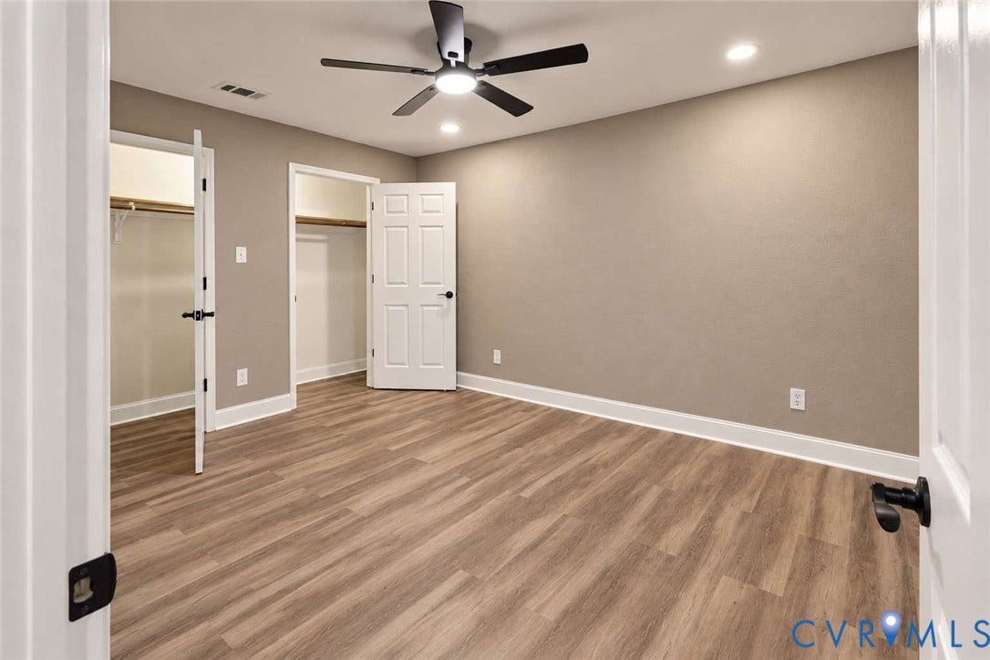 7300 Key Deer Court, Deer Run, Midlothian, VA 23112 Wood-finish flooring, neutral wall tones, multi-panel doors with matte black hardware, and a center ceiling fan with integrated lighting