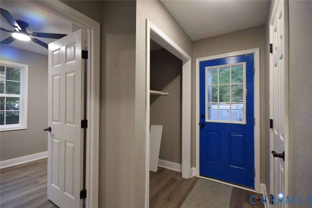 7300 Key Deer Court, Deer Run, Midlothian, VA 23112 Entryway featuring a blue exterior door with a multi-pane glass insert, wood-finish flooring, white panel doors, and a ceiling fan with integrated lighting