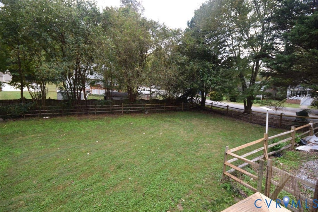 7300 Key Deer Court, Deer Run, Midlothian, VA 23112 Expansive backyard featuring a level lawn, mature trees, and split-rail perimeter fencing