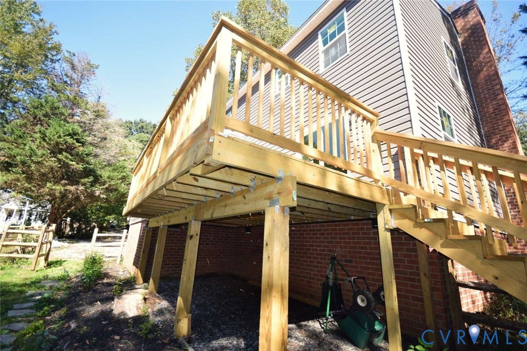7300 Key Deer Court, Deer Run, Midlothian, VA 23112 Elevated wooden deck featuring railing, staircase, and support posts, set against a two-story exterior with brick foundation and horizontal siding