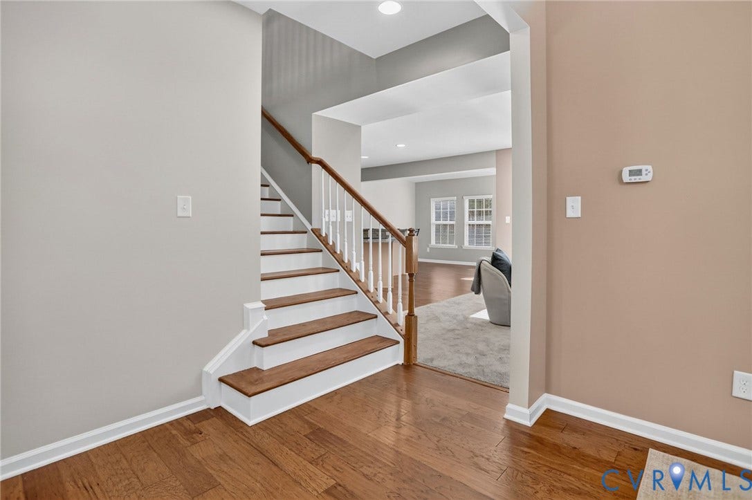 10851 White Dogwood Drive, Oakmont Villas, New Kent, VA 23140 Staircase featuring wood-finish treads, white risers, and a wooden handrail with white balusters, complemented by wood-finish flooring and recessed lighting