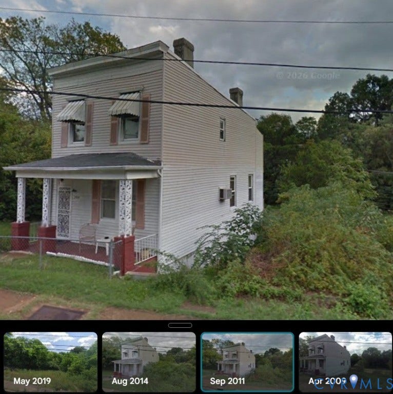 Previous Home on property 
Two-story residence featuring horizontal siding, a covered front porch with decorative posts, and dual masonry chimneys