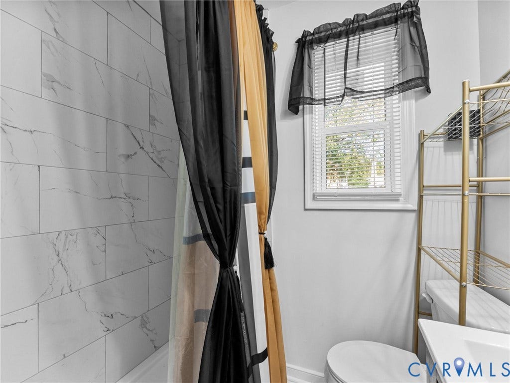 1826 Claiborne Street, Byrd Park, Richmond, VA 23220 Bathroom featuring wall-to-wall large format rectified tile with a veined pattern, window with horizontal blinds, and a white sink
