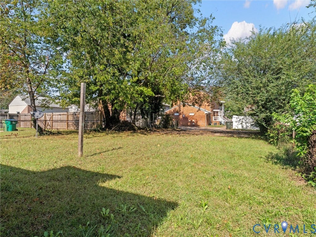 1826 Claiborne Street, Byrd Park, Richmond, VA 23220 Expansive backyard featuring mature trees, a wood-post fence, and a level lawn