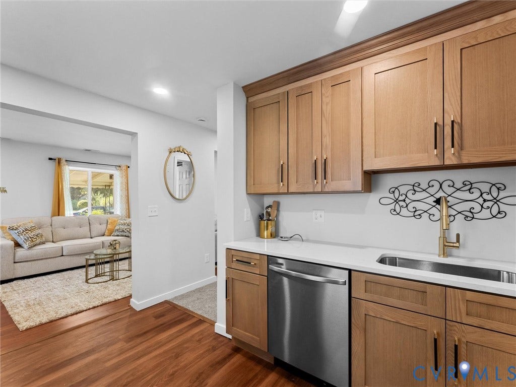 1826 Claiborne Street, Byrd Park, Richmond, VA 23220 Kitchen area featuring shaker-style wood cabinetry, stone-finish countertops, stainless steel dishwasher, and metallic hardware, complemented by wood-finish flooring