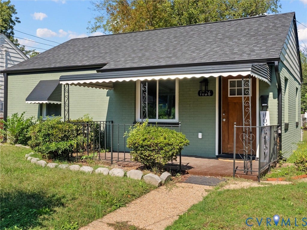 1826 Claiborne Street, Byrd Park, Richmond, VA 23220 Brick exterior with a covered front porch, decorative metal railings, an awning, and a wooden front door featuring a glass inset