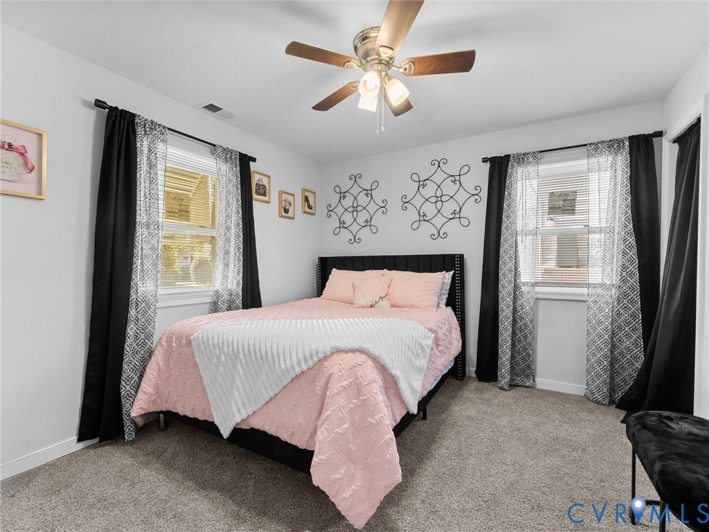 1826 Claiborne Street, Byrd Park, Richmond, VA 23220 Bedroom interior featuring neutral wall-to-wall carpeting, dual windows, and a multi-blade ceiling fan with an integrated light fixture