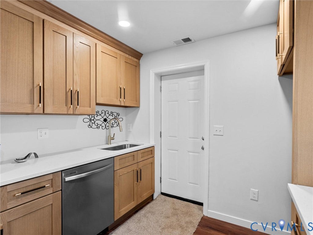 1826 Claiborne Street, Byrd Park, Richmond, VA 23220 Light wood cabinetry with matte black hardware, solid-surface countertops, undermount stainless steel sink, pull-down faucet, and integrated stainless steel dishwasher