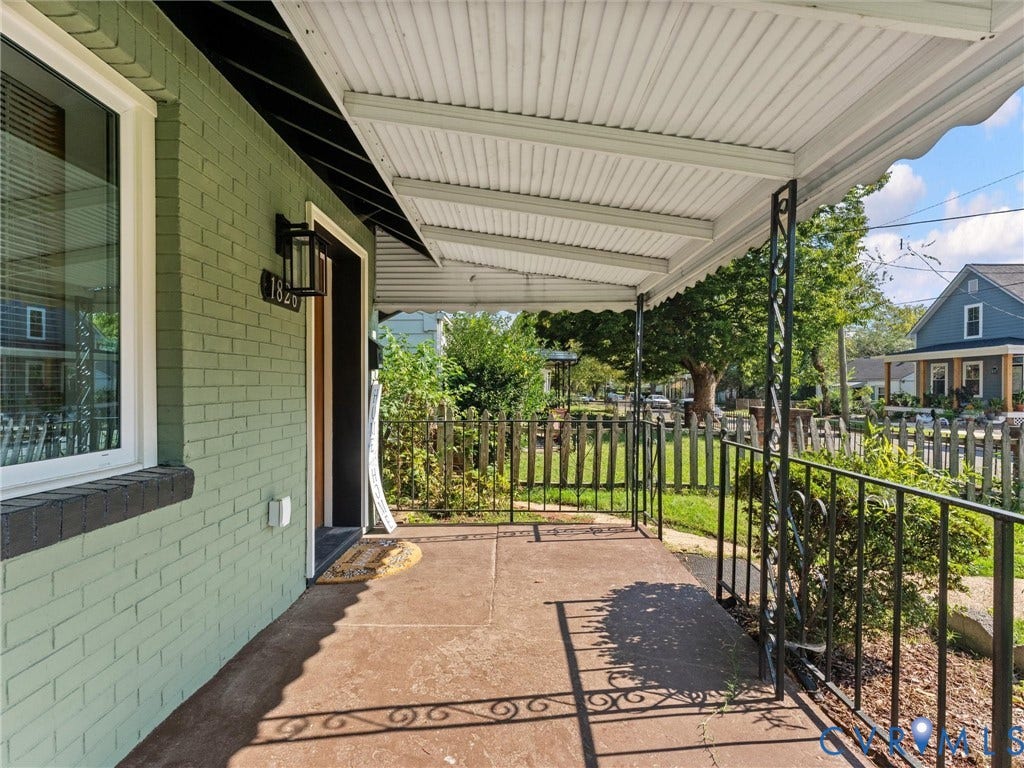 1826 Claiborne Street, Byrd Park, Richmond, VA 23220 Covered front porch featuring a concrete floor, decorative metal railings, and a green painted brick exterior