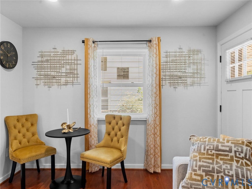 1826 Claiborne Street, Byrd Park, Richmond, VA 23220 Interior space featuring wood-finish flooring, a double-hung window with horizontal blinds, and a white six-panel door with recessed molding