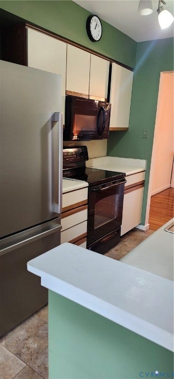 12400 New Point Drive, Wilde Lake, Henrico, VA 23233 Kitchen featuring cabinetry with wood-tone accents, white countertops, a stainless steel refrigerator, and black built-in oven and microwave