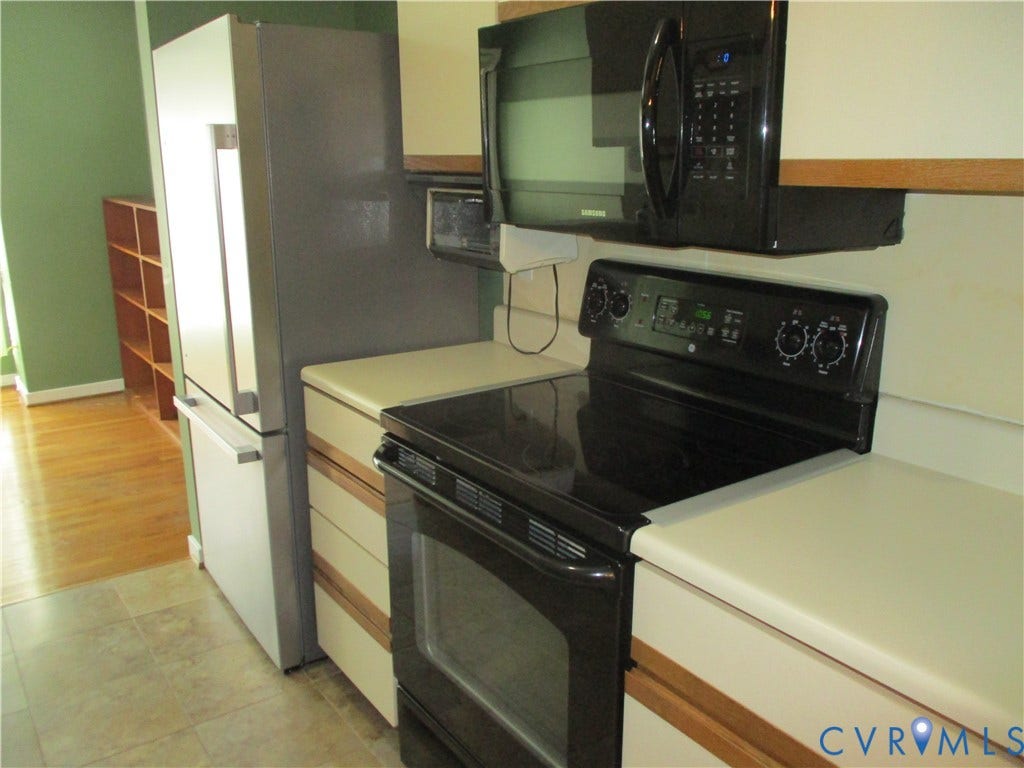 12400 New Point Drive, Wilde Lake, Henrico, VA 23233 Kitchen featuring a stainless steel refrigerator, black electric range, black over-the-range microwave, solid-surface countertops, and wood-finish flooring