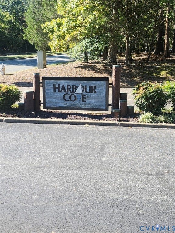 12400 New Point Drive, Wilde Lake, Henrico, VA 23233 Community monument sign featuring rustic wood-finish posts and textured paneling surrounded by mature landscaping
