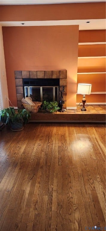 12400 New Point Drive, Wilde Lake, Henrico, VA 23233 Wood-finish flooring, tiled fireplace surround, raised hearth, and built-in shelving