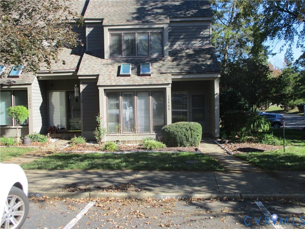 12400 New Point Drive, Wilde Lake, Henrico, VA 23233 Multi-level exterior featuring horizontal lap siding, a shingled roof, dual skylights, bay windows, and a concrete front walkway
