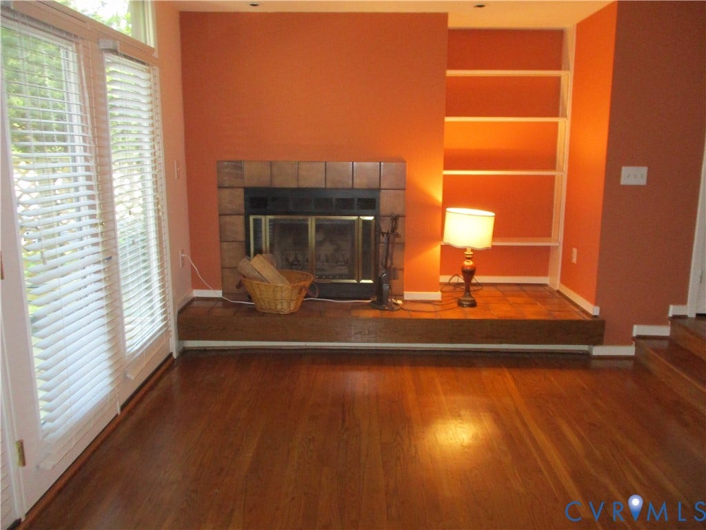 12400 New Point Drive, Wilde Lake, Henrico, VA 23233 Fireplace with tile surround and raised hearth, hardwood flooring, built-in shelving, and double-glass door entry