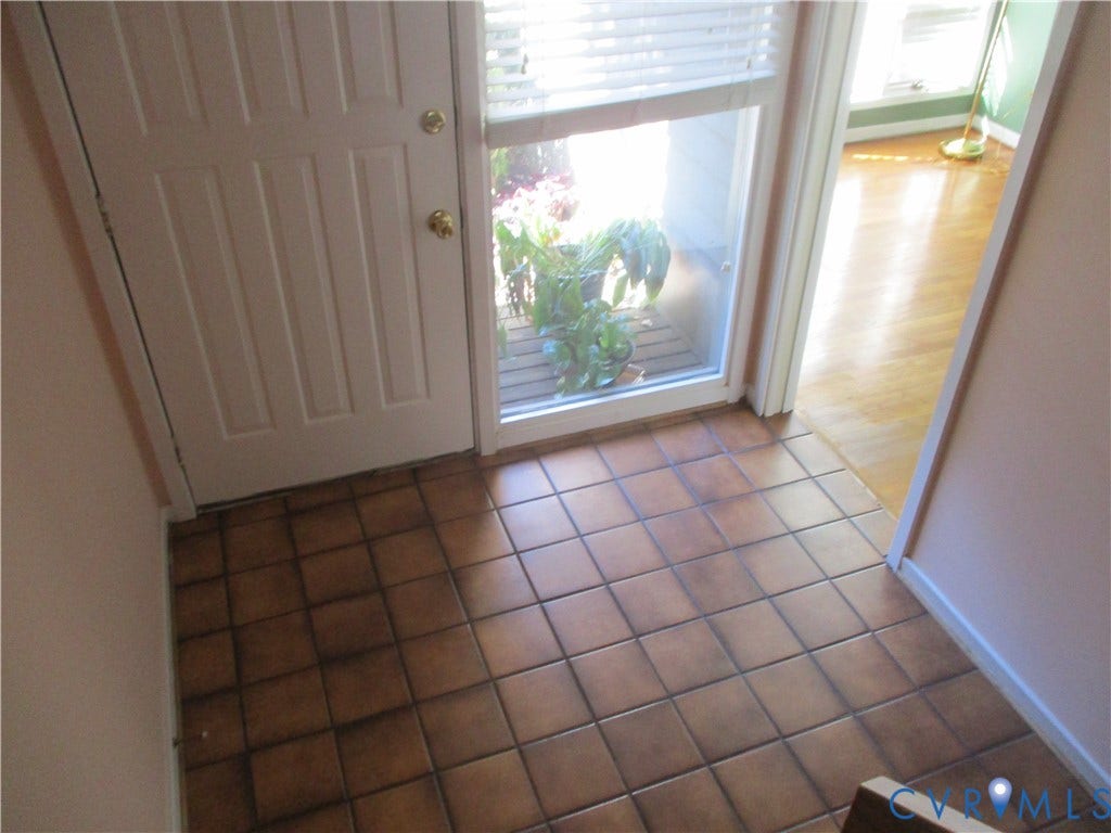 12400 New Point Drive, Wilde Lake, Henrico, VA 23233 Entryway featuring ceramic tile flooring, a multi-panel door with metallic hardware, and a side light window with horizontal blinds
