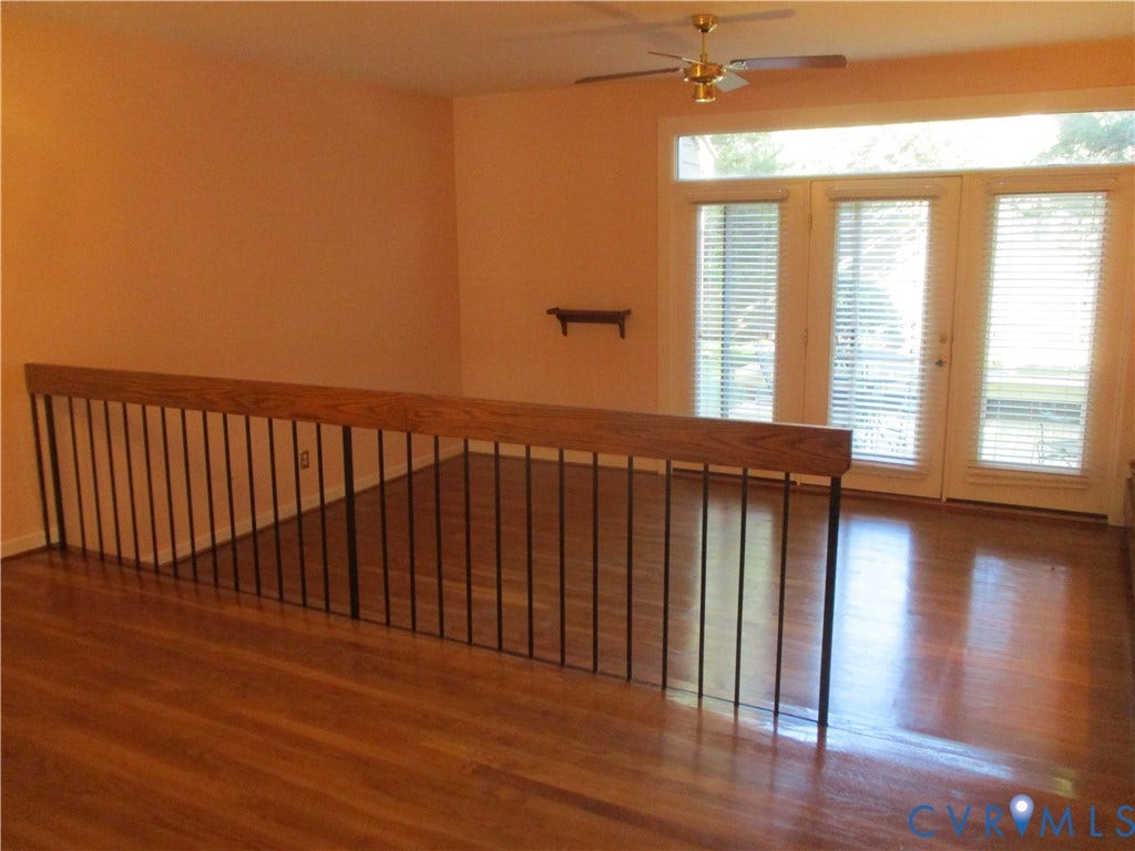 12400 New Point Drive, Wilde Lake, Henrico, VA 23233 Wood-finish flooring, full-light French doors with integrated transom windows, metal balustrade with a wooden handrail, and a ceiling-mounted fan
