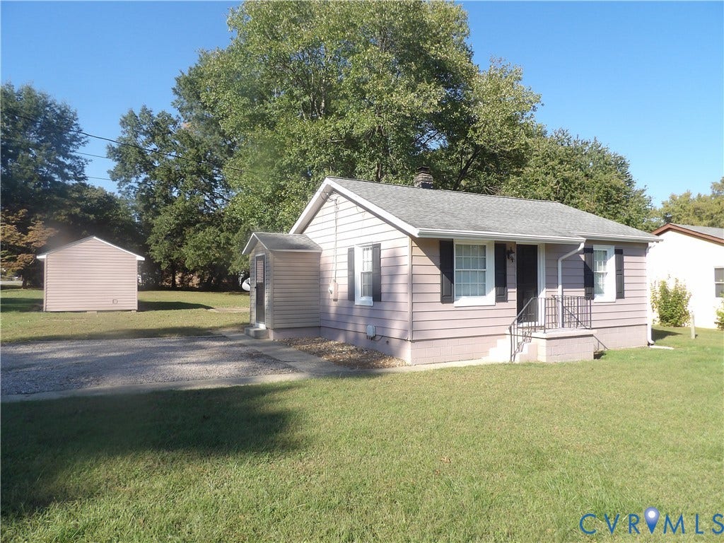 3206 South Street, Chester, VA 23831 Single-story exterior with horizontal siding, dark decorative shutters, metal handrails at the entryway, a gravel driveway, and a detached structure