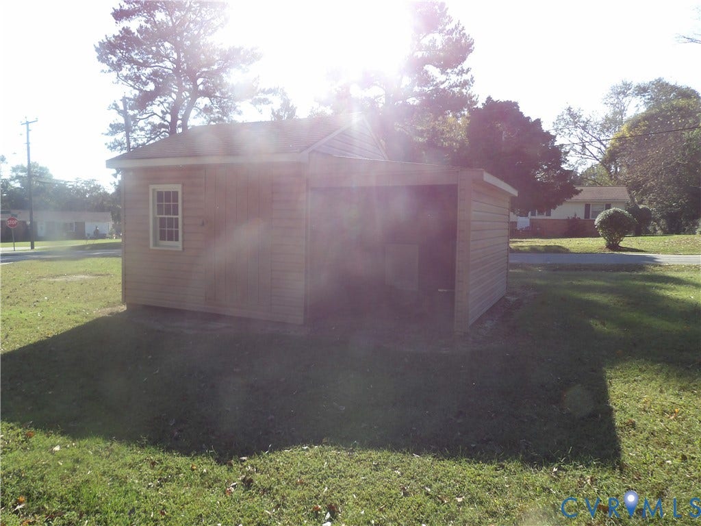 3206 South Street, Chester, VA 23831 Outbuilding featuring horizontal lap siding, a pitched roof, a multi-pane window, and an attached open-air storage area
