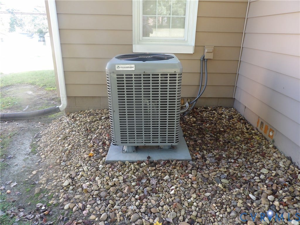 3206 South Street, Chester, VA 23831 Exterior HVAC unit mounted on a concrete pad, surrounded by a stone landscape border