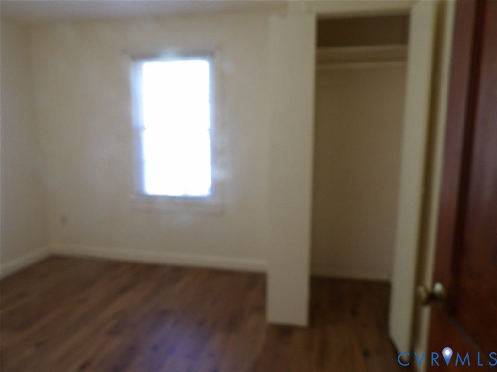 3206 South Street, Chester, VA 23831 Room featuring wood-finish flooring, a single window, and a built-in closet with an interior hanging rod
