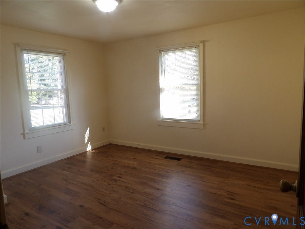 3206 South Street, Chester, VA 23831 Interior room featuring wood-finish flooring, neutral wall tones, and two windows with horizontal blinds