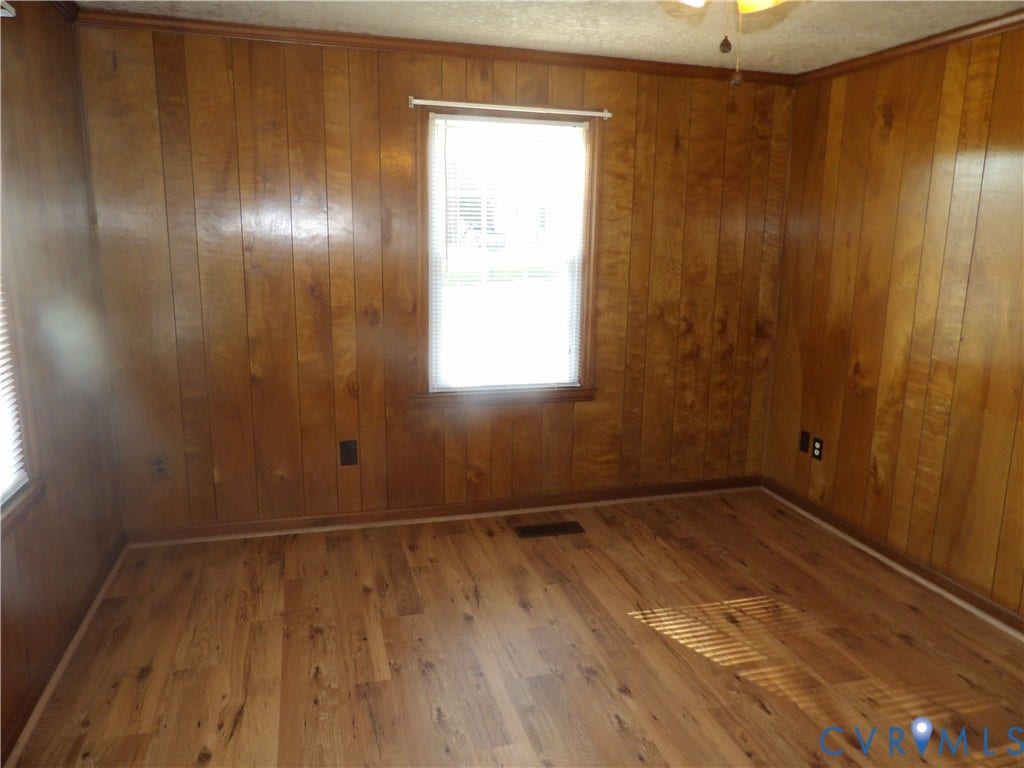 3206 South Street, Chester, VA 23831 Wood-paneled interior walls, wood-finish flooring, and a central window with horizontal blinds