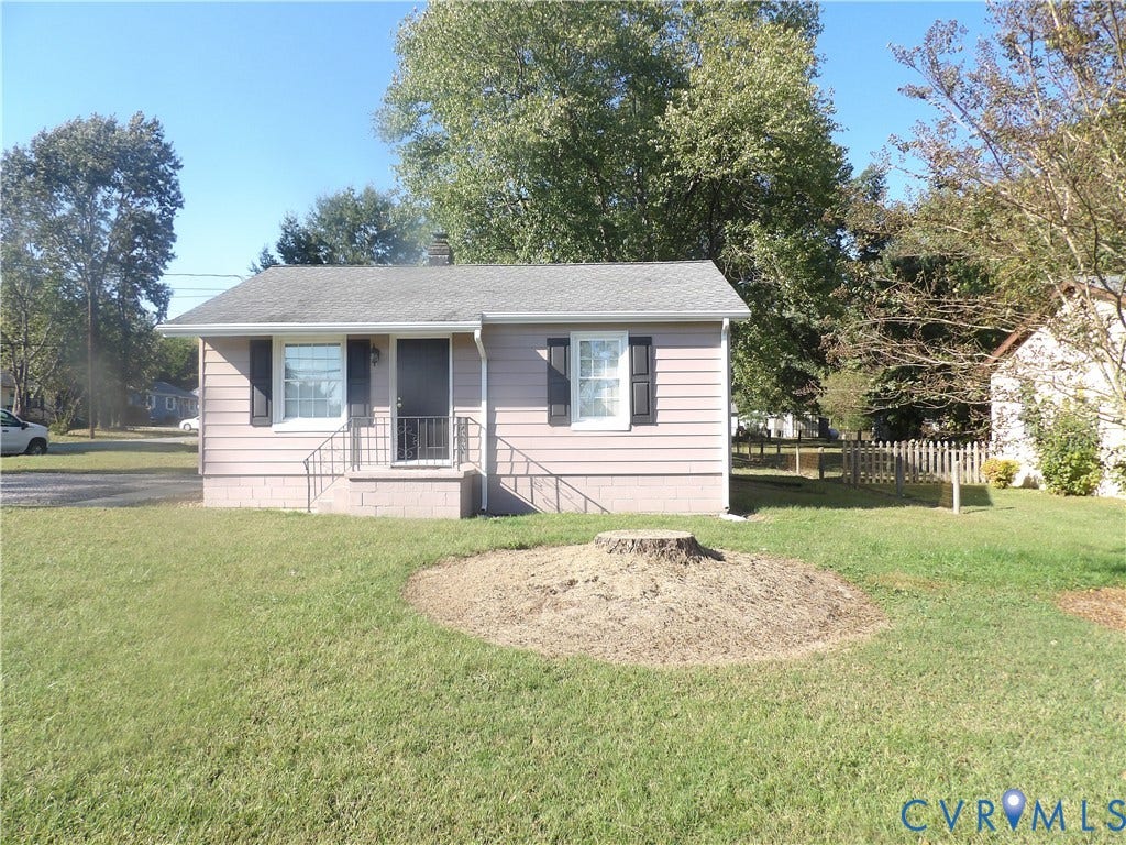 3206 South Street, Chester, VA 23831 Pink vinyl-sided cottage with a front-gable roof, featuring a covered front porch with metal railings and multiple windows