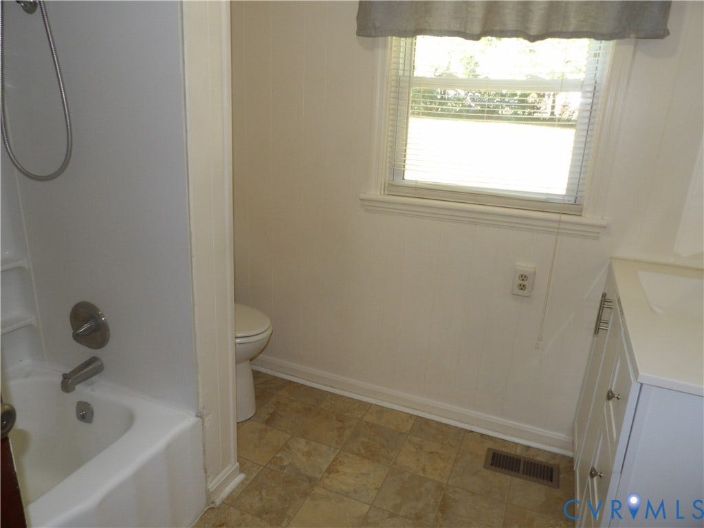 3206 South Street, Chester, VA 23831 Bathroom featuring a shower-tub combination, white vanity with nickel-finish hardware, window with horizontal blinds, and tiled flooring