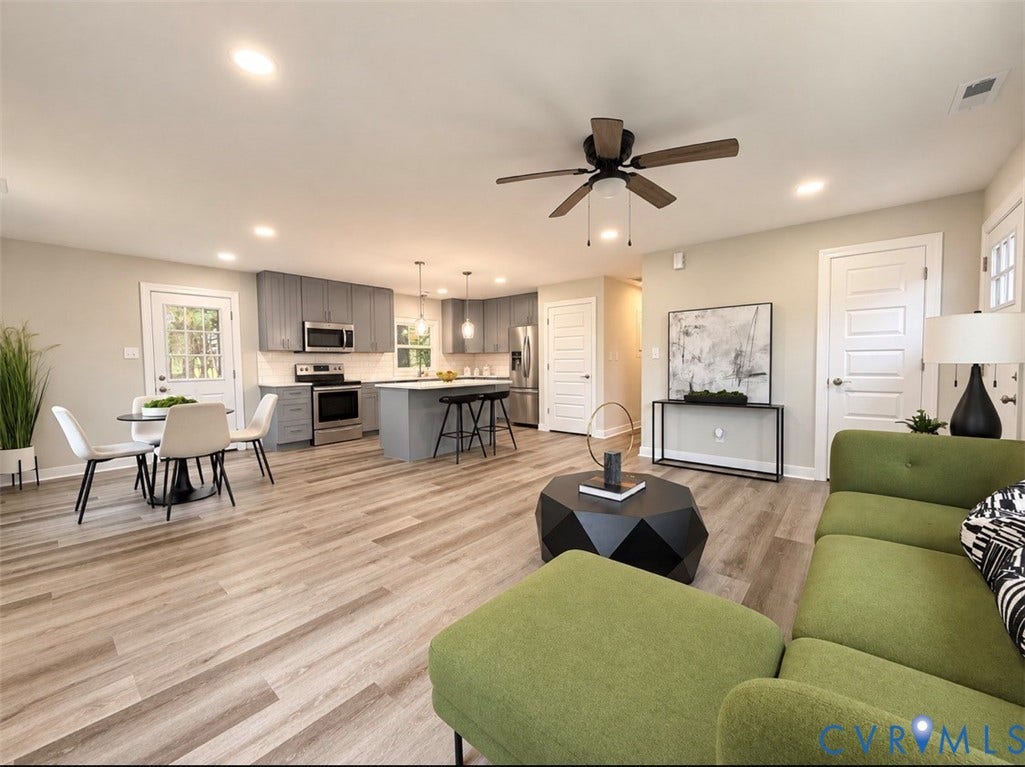 2800 Harris Hill Road, Dunnsville, VA 22454 Open floor plan featuring wood-finish flooring, a kitchen with a center island, gray shaker-style cabinetry, stainless steel appliances, and recessed lighting