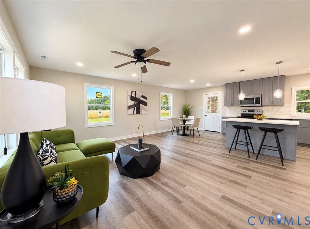 2800 Harris Hill Road, Dunnsville, VA 22454 Open-concept interior featuring wood-finish flooring, recessed lighting, and a kitchen equipped with stone-surface countertops, a breakfast bar, and stainless steel appliances