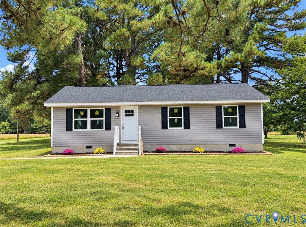 2800 Harris Hill Road, Dunnsville, VA 22454 Single-story residence featuring grey vinyl siding, black louvered shutters, shingled roof, front entry with white door, and mature evergreen trees