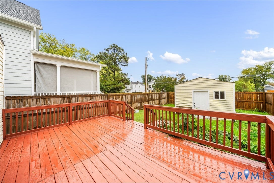 1802 Maury Street, Richmond, VA 23224 Elevated wood deck featuring protective railings, screened porch, detached storage structure, and fenced perimeter
