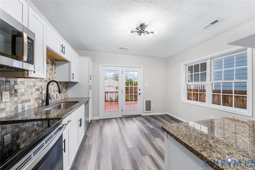 1802 Maury Street, Richmond, VA 23224 Kitchen featuring white shaker-style cabinetry, stone-finish countertops, mosaic tile backsplash, wood-finish flooring, and double glass-paneled doors