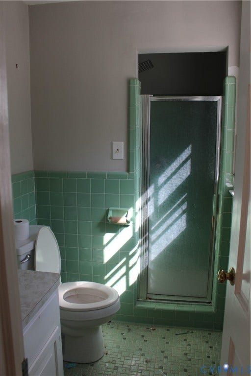 4101 Vauxhall, Chesterfield, VA 23234 Bathroom featuring light green ceramic wall tiling, matching green tiled flooring, a built-in shower stall with a glass door, and an integrated recessed soap dish