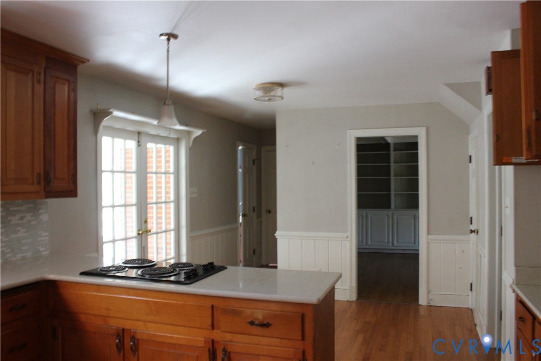 4101 Vauxhall, Chesterfield, VA 23234 Kitchen featuring wood cabinetry, solid surface countertops, an integrated cooktop, beadboard wainscoting, and wood-finish flooring