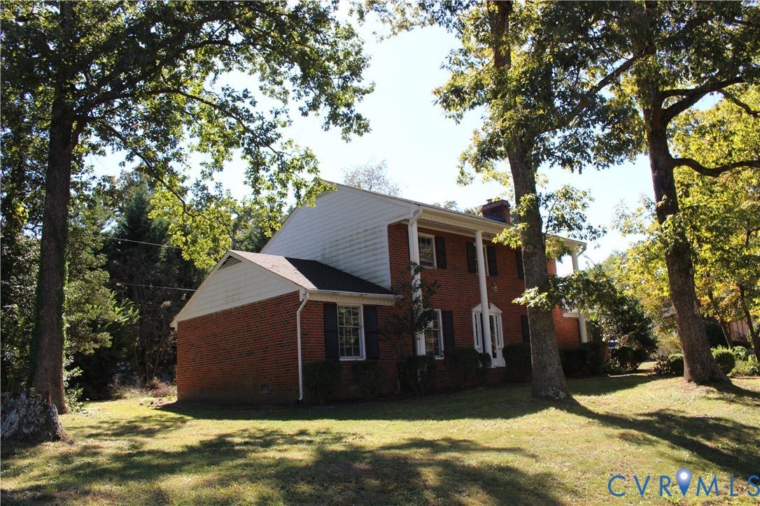 4101 Vauxhall, Chesterfield, VA 23234 Two-story exterior featuring a brick and horizontal siding facade, a covered porch with columns, and shuttered windows, situated on a lot with mature trees