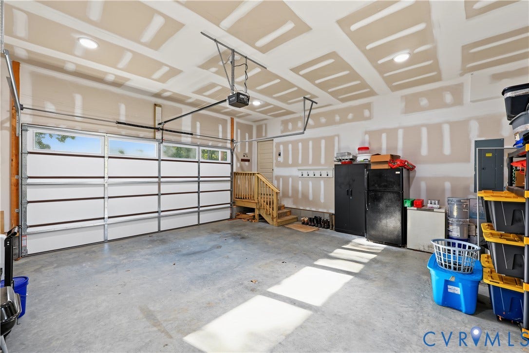 3851 County Line Road, Flemings Mill, Goochland, VA 23084 Multi-car garage featuring a sectional door with windows, concrete flooring, recessed lighting, and wooden stair access to the residence