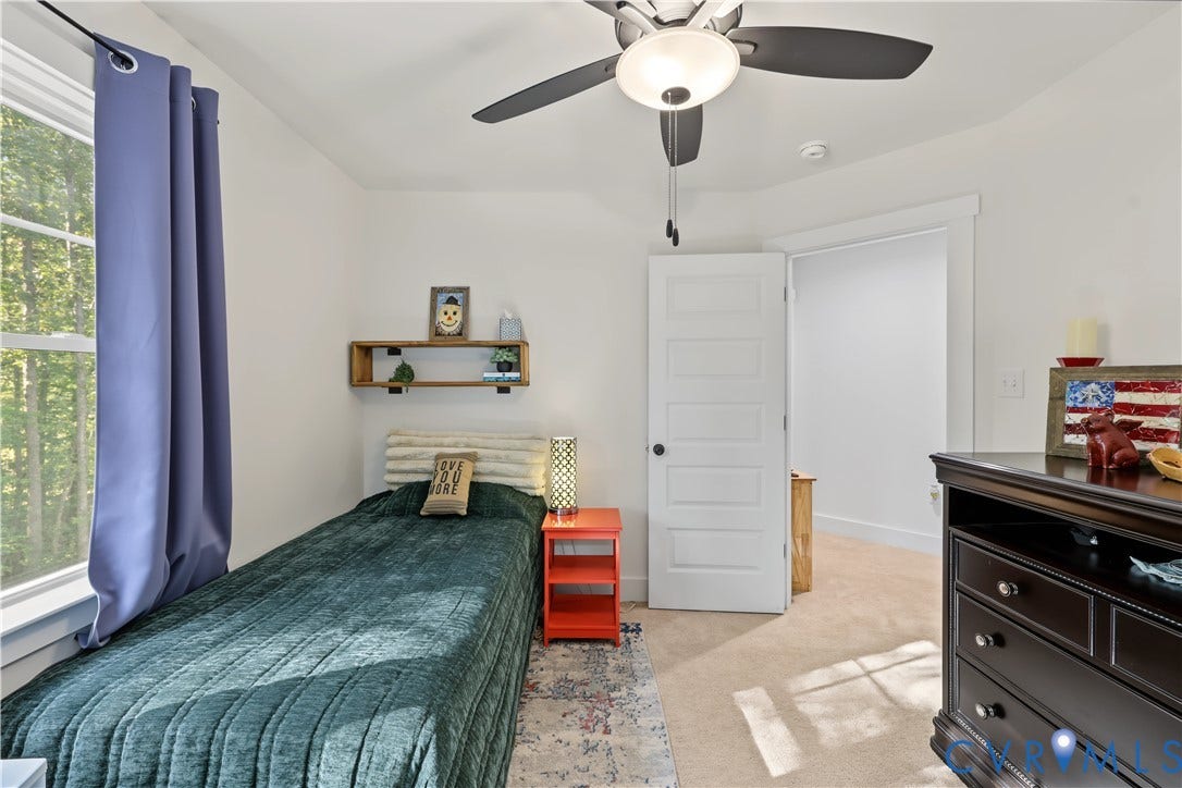 3851 County Line Road, Flemings Mill, Goochland, VA 23084 Neutral-toned room featuring a central ceiling fan with an integrated light fixture, wall-to-wall carpeting, and a five-panel interior door