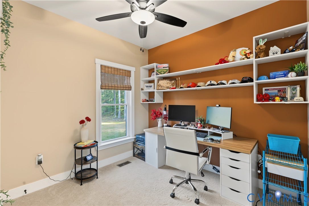 3851 County Line Road, Flemings Mill, Goochland, VA 23084 Built-in white shelving, integrated desk surface with drawer storage, ceiling fan with light fixture, and window with woven shade