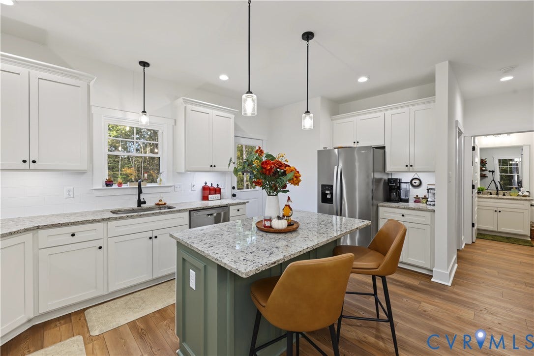 3851 County Line Road, Flemings Mill, Goochland, VA 23084 Kitchen featuring white shaker cabinetry, speckled stone countertops, a contrasting green center island, wood-finish flooring, and pendant lighting