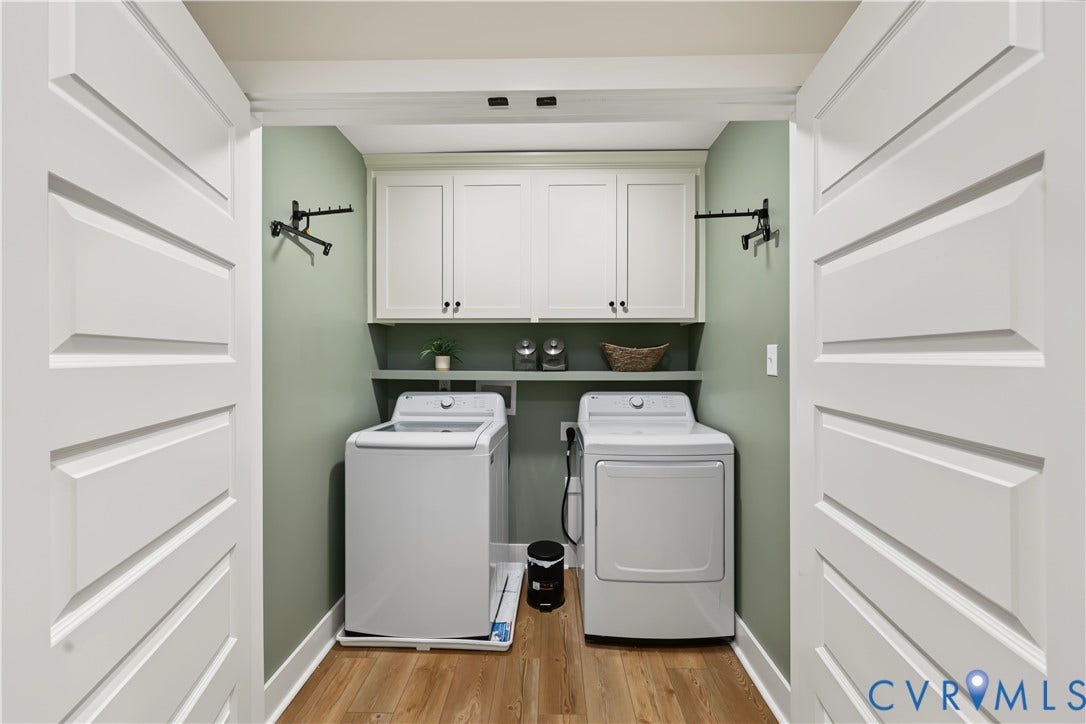 3851 County Line Road, Flemings Mill, Goochland, VA 23084 Laundry area featuring white shaker-style wall cabinetry, built-in shelving, wood-finish flooring, and dual-door entry