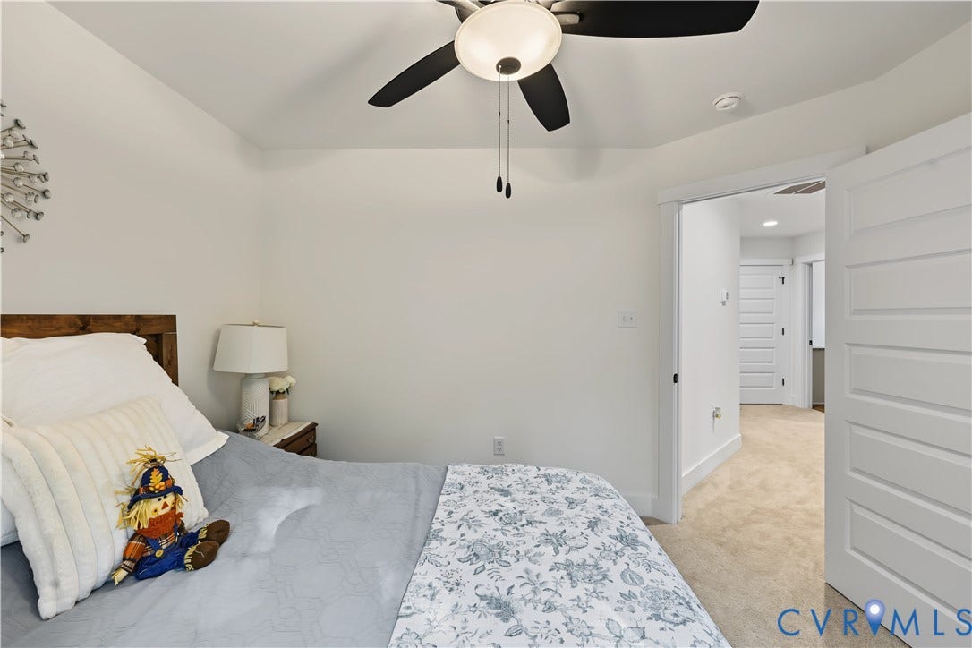 3851 County Line Road, Flemings Mill, Goochland, VA 23084 Neutral-toned room featuring a vaulted ceiling, ceiling fan with integrated lighting, and white five-panel interior doors