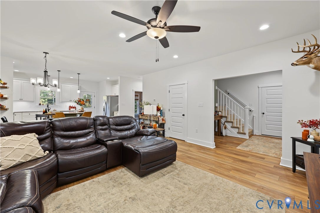 3851 County Line Road, Flemings Mill, Goochland, VA 23084 Open-concept interior featuring wood-finish flooring, a multi-blade ceiling fan, recessed lighting, and a white staircase with a wooden handrail