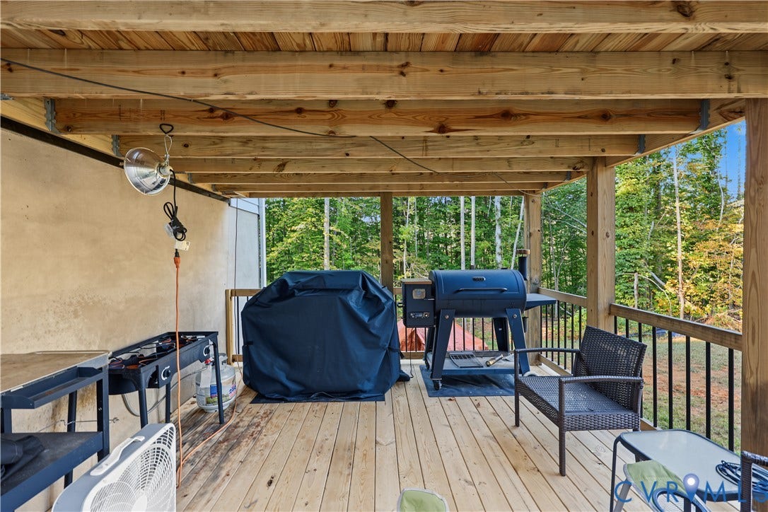 3851 County Line Road, Flemings Mill, Goochland, VA 23084 Covered wood deck featuring exposed beam ceiling and black metal railing